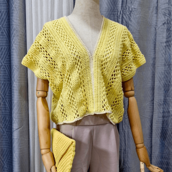 Yellow handmade cotton top named 'Marcella' by Arty-Crafty by Vanessa, featuring a delicate, flowy design with a V-neckline and intricate stitching, displayed on a mannequin