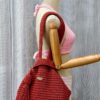 Riley Reversible Bag in a vibrant red color, handcrafted from macrame cotton yarn, displayed on a white fur surface with a tassel detail.