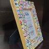 Colorful Rainbow Mosaic Frame displayed on a wooden table, featuring vibrant square tiles in various colors surrounding a 4x6 inch photo. The frame adds a lively and artistic touch to the decor.