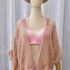 Handmade rose-colored cotton kimono top named 'Suzy - Kimono Top' by Arty-Crafty by Vanessa, featuring a loose, free-size design with wide sleeves, displayed on a hanger against a colorful background.