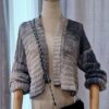 Handmade striped cardigan named 'Isabela Cardigan' by Arty-Crafty by Vanessa, crafted from a blend of cotton and acrylic yarn in shades of gray, featuring a lightweight, free-size design with an open front