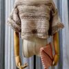 Handmade beige-colored crochet top named 'Aurora Top' by Arty-Crafty by Vanessa, featuring a lightweight, free-size design made from cotton and acrylic yarn, displayed on a mannequin with a matching crochet clutch.