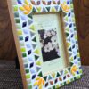 Handcrafted vibrant mosaic photo frame by Mosaicbyaroma, featuring colorful ceramic tiles in a 22x17 cm frame, perfect for displaying a 15x10 cm photo. Ideal for home décor or as a unique gift.