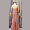 Handmade crochet Charmaine Set in a blush pink tone, featuring a sleeveless crop top and wide-leg pants made from a cotton-acrylic blend. The set is shown on a wooden mannequin with a beige crochet bucket hat, offering a casual yet elegant look.