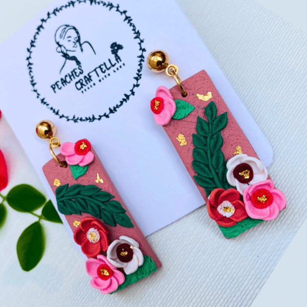 Rectangular earrings with pink roses, green leaves, and gold accents by Ishara Malshani Settinayake of Peaches Craftella.