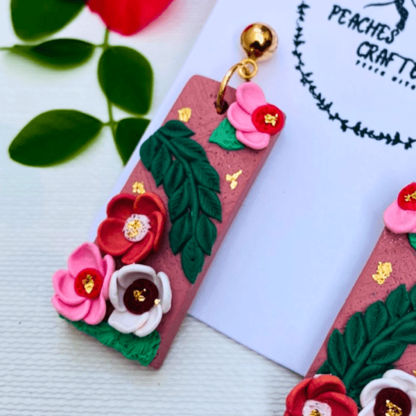 Rectangular earrings with pink roses, green leaves, and gold accents by Ishara Malshani Settinayake of Peaches Craftella.