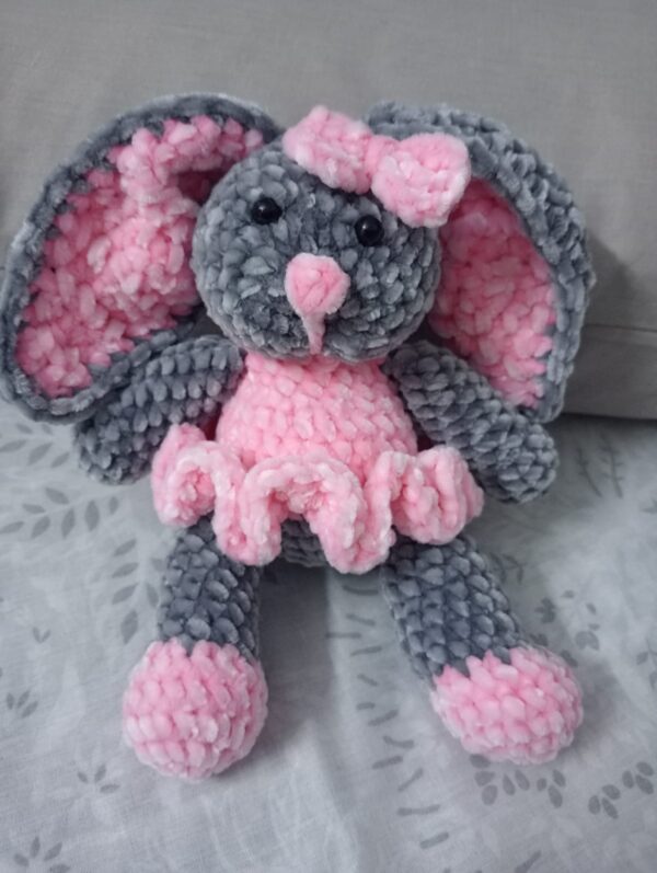 Handmade bunny plushie made with soft gray and pink velvet yarn, featuring floppy ears, a pink bow, and an adorable outfit. Perfect for babies and toddlers as a soft toy or baby shower gift.