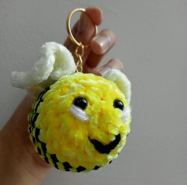 Handmade honey bee keychain made with soft yellow velvet yarn, featuring black stripes, cute wings, and a sturdy keyring for easy attachment to keys or bags. Perfect for bee lovers and as a fun accessory.