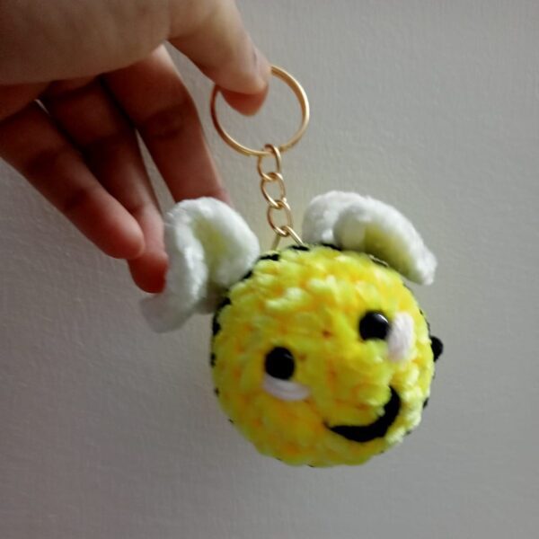 Handmade honey bee keychain made with soft yellow velvet yarn, featuring black stripes, cute wings, and a sturdy keyring for easy attachment to keys or bags. Perfect for bee lovers and as a fun accessory.