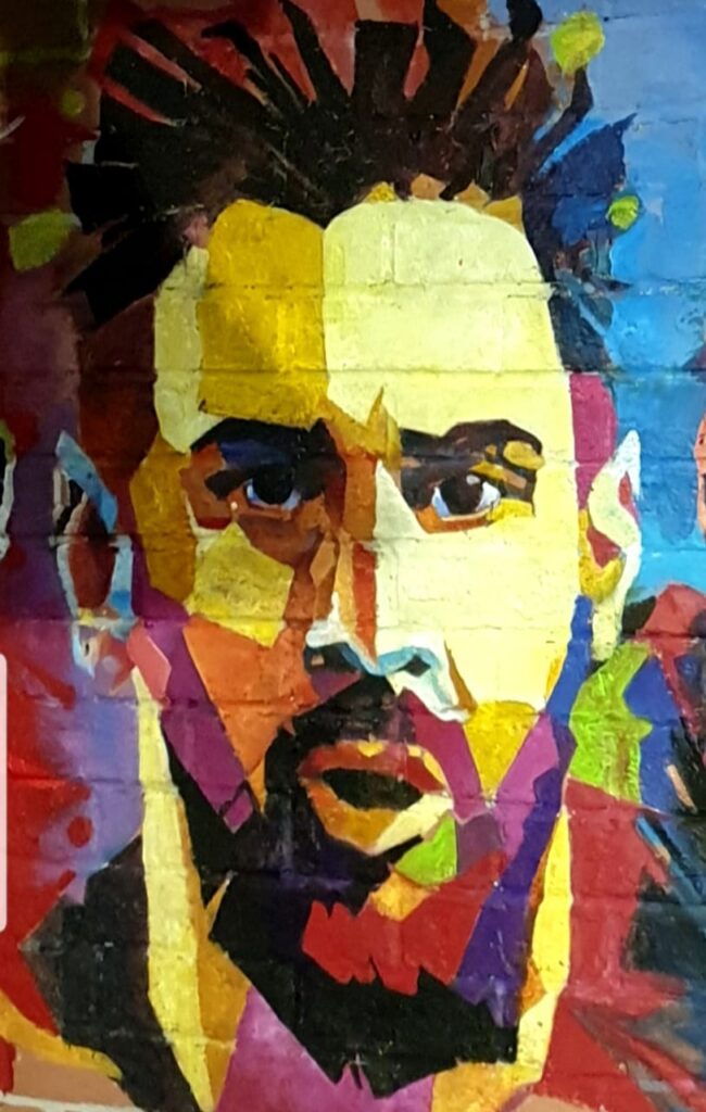 Painting of Sadiq Muhamed, showing his wall painting Lionel Messi