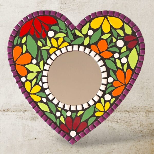 A Vibrant Heart Mosaic Mirror with a colorful floral design, handcrafted with ceramic tiles, featuring a 10 cm round mirror in the center on a 25 x 25 cm MDF base.