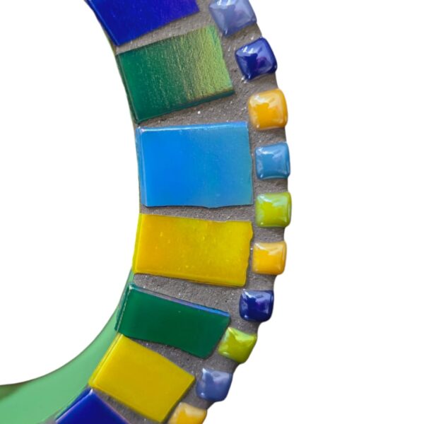 A handcrafted mosaic letter "D" featuring vibrant glass tiles in shades of blue, yellow, green, and purple, fixed on an MDF base. This colorful letter is perfect for home décor, kids' rooms, office spaces, or creating custom nameplates.