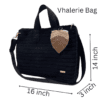 Handmade crochet Vhalerie Bag in black, featuring a detachable and adjustable strap, metallic snap button fastener, and decorative macramé leaf charm. The bag measures 14 inches in height, 16 inches in length, and 3 inches in width.