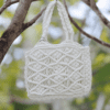 Handcrafted pure white macrame bag with intricate knotting, compact size, 19 cm wide, 16 cm high, and 5 cm deep.