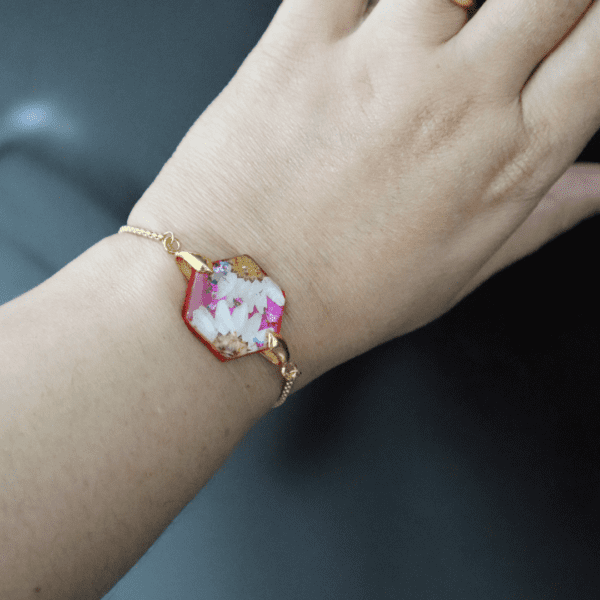 Blossom Hexagon Resin Bracelet with preserved flowers encased in resin, featuring an adjustable gold-plated chain.