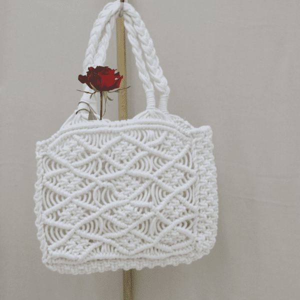 Handcrafted pure white macrame bag with intricate knotting, compact size, 19 cm wide, 16 cm high, and 5 cm deep.