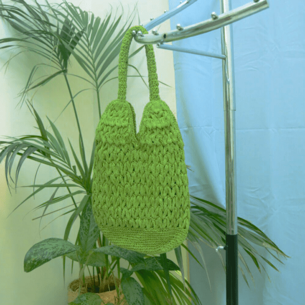 Handmade green raffia bag with magnetic clasp, 13 inches wide, 17.5 inches long, and 25 inches from top of handle.