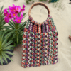 Multicolor handwoven macrame bag with wooden handle, zipper closure, and cotton lining, 12 inches wide and 18 inches long.