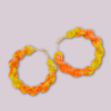 Handmade twisted macrame earrings in marigold shades of yellow and orange, circular hoop design by Rita Lewis.