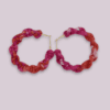 Handmade twisted macrame earrings in Adenium colors (pink and red), circular hoop design by Rita Lewis.