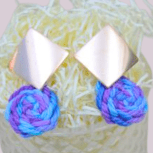 Handmade earrings with a square metal stud and round cornflower-colored macrame dangle in blue and purple.