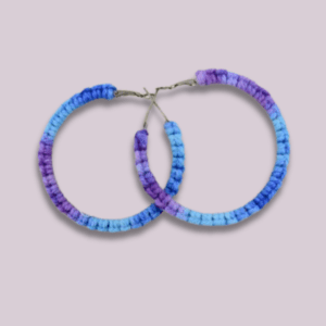 Handmade cornflower-colored macrame earrings in a circular hoop design by Rita Lewis.