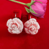 Handmade crochet rose earrings in a soft peach color, floral design.