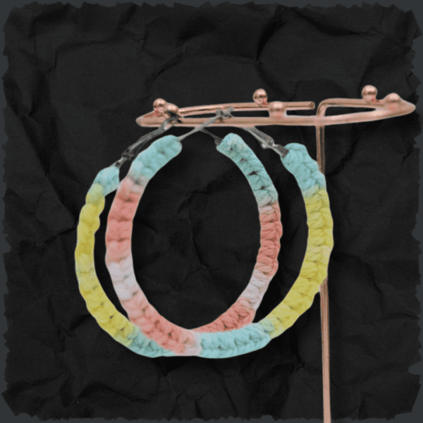 Handmade Lutino macrame earrings featuring pastel colors in a circular hoop design by Rita Lewis.