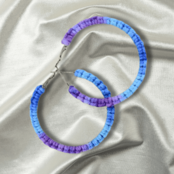 Handmade cornflower-colored macrame earrings in a circular hoop design by Rita Lewis.