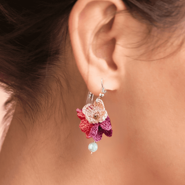 Handmade pink crochet flower earrings with pearl accent, delicate floral design.