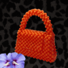 Handcrafted orange beaded bag with a unique, eye-catching design.