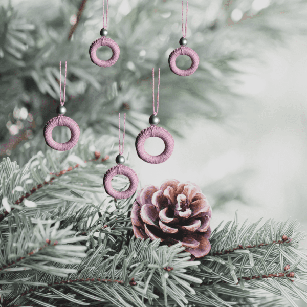 Handmade pink macrame Christmas ornament with a 2.25-inch diameter, featuring delicate craftsmanship.