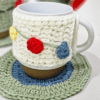 Handmade Blissful Brew Set featuring a crochet mug cover and matching coaster. Customizable colors include blue, red, green, and festive patterns. A perfect gift for tea and coffee lovers.