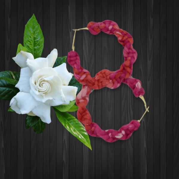 Handmade twisted macrame earrings in Adenium colors (pink and red), circular hoop design by Rita Lewis.