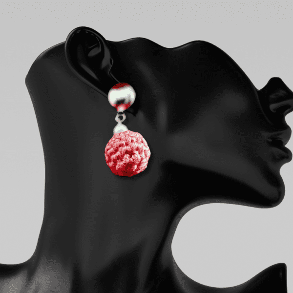 Handmade earrings with round metal stud and pink macrame dangle, designed by Rita Lewis.