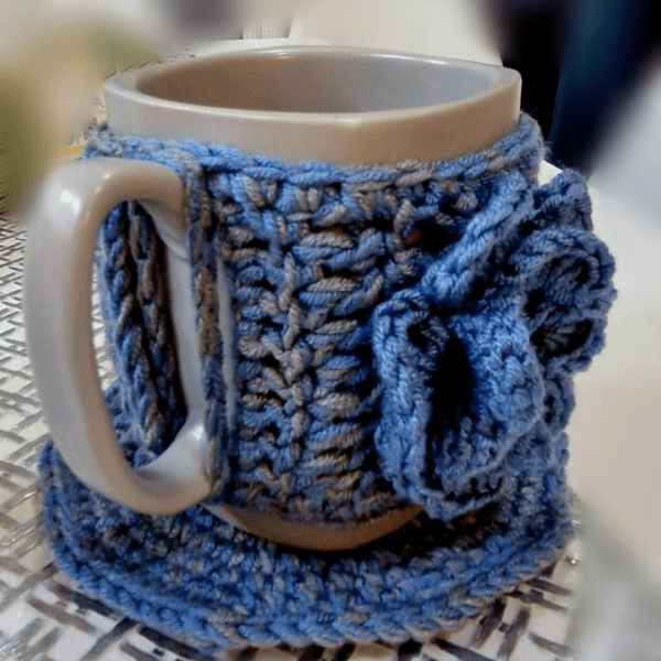 Handmade Blissful Brew Set featuring a crochet mug cover and matching coaster. Customizable colors include blue, red, green, and festive patterns. A perfect gift for tea and coffee lovers.