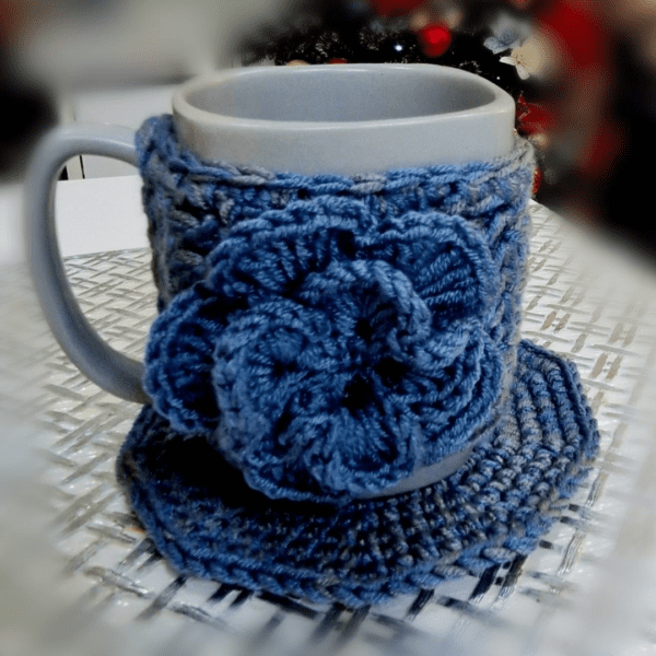 Handmade Blissful Brew Set featuring a crochet mug cover and matching coaster. Customizable colors include blue, red, green, and festive patterns. A perfect gift for tea and coffee lovers.