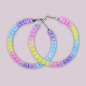 Handmade macrame earrings in pastel unicorn colors (pink, purple, blue, yellow), circular hoop design by Rita Lewis.