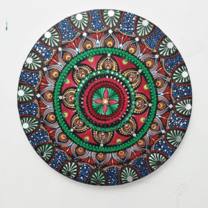 Blooming Radiance Mandala, a 40 cm handcrafted mandala art on canvas by Krutika Jariwala, featuring intricate patterns with bold red, green, and blue hues.