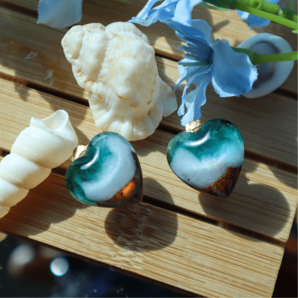 Handcrafted heart-shaped clip-on earrings depicting turquoise water, white waves, and golden sand, with golden stainless steel backs, lightweight and elegant.