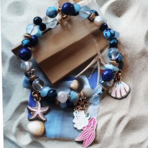 Ocean-themed handmade bracelet with Lapis Lazuli, Clear Quartz, Blue Tiger’s Eye, Aquamarine, Freshwater Pearls, and sea-inspired charms: Mermaid Tail, Sea Shell, and Starfish.