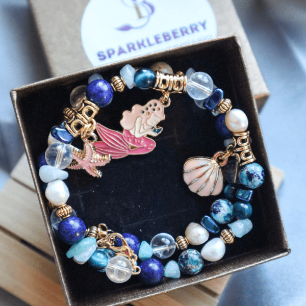 Ocean-themed handmade bracelet with Lapis Lazuli, Clear Quartz, Blue Tiger’s Eye, Aquamarine, Freshwater Pearls, and sea-inspired charms: Mermaid Tail, Sea Shell, and Starfish.