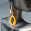 Handmade yellow resin earrings with embedded abalone shells, gold-plated hypoallergenic stainless steel hooks, measuring 7 cm