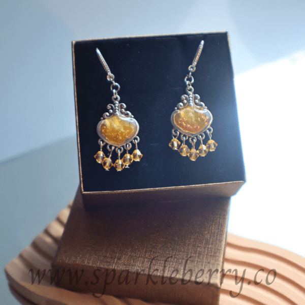 Handcrafted golden resin earrings with genuine Swarovski beads and silver-toned filigree design