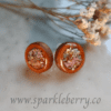 Handcrafted wooden bezel ear studs with dried flowers and gold flakes encased in resin, lightweight at 1.5g, with a 2 cm diameter.