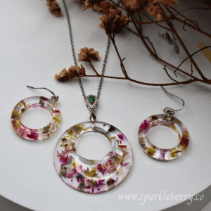 Captivating floral jewelry set with a radiant resin pendant and lightweight earrings, featuring vibrant dried flowers encased in premium resin.