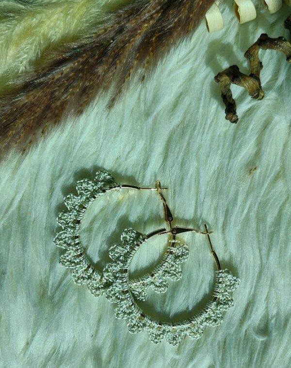 Close-up of handcrafted crochet hoop earrings with beads, available in multiple colors including peach, cream, black, and green.