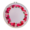 Hand-embroidered floral wreath wall art featuring pink, red, and blush roses with green leaves, framed in a 10-inch wooden hoop, created by Anu Paulson.