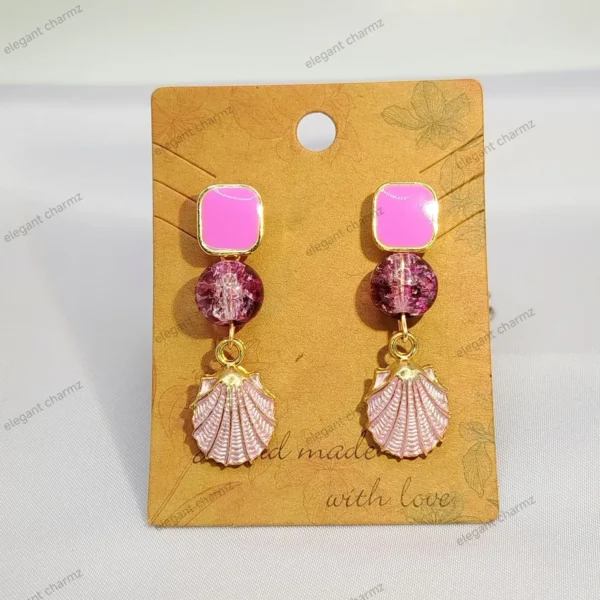 A pair of elegant blush pink crystal dangle earrings featuring soft pink square studs, crackle effect pink crystal beads, gold-plated shell charms, and stainless steel ear studs, displayed on a handmade jewelry card.