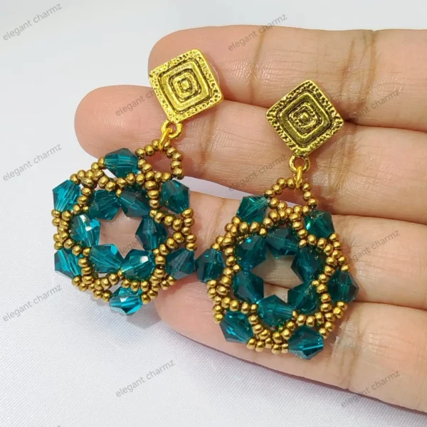 Handmade Emerald Beaded Earrings with faceted teal crystal beads and gold accents, featuring a geometric woven design, held in hand.